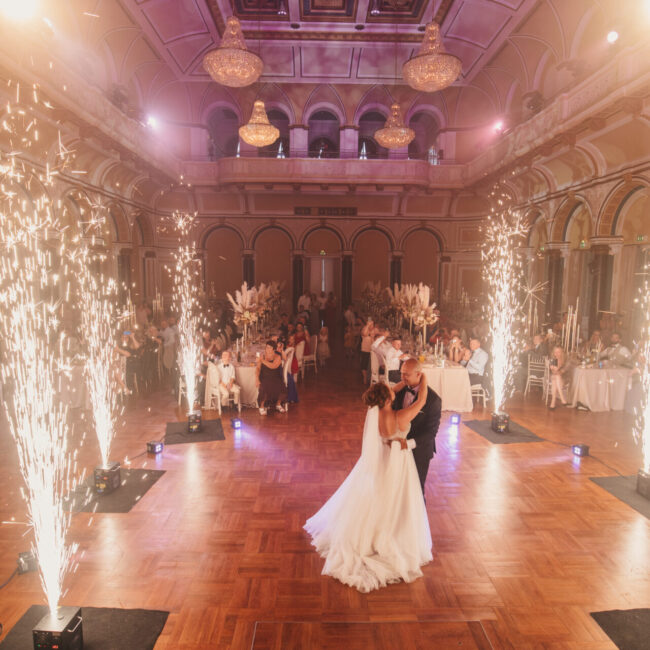 Brautpaar Bräutigam Braut im Brautkleid beim Hochzeitstanz Hochzeithalle mit Feuerwerk