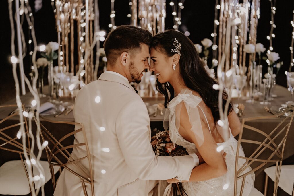 Foto eines verliebten Brautpaares umgeben von einem märchenhaften Lichterketten Zauber bei einer Outdoor Wedding.